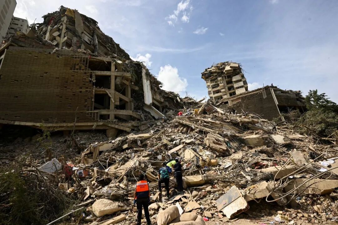 6月25日，委内瑞拉拉瓜伊拉地震后，人们在倒塌建筑的瓦砾中搜寻伤员。